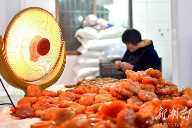 1月6日,双峰县永丰街道犁头社区一乔饼加工坊,工人在为乔饼定型.